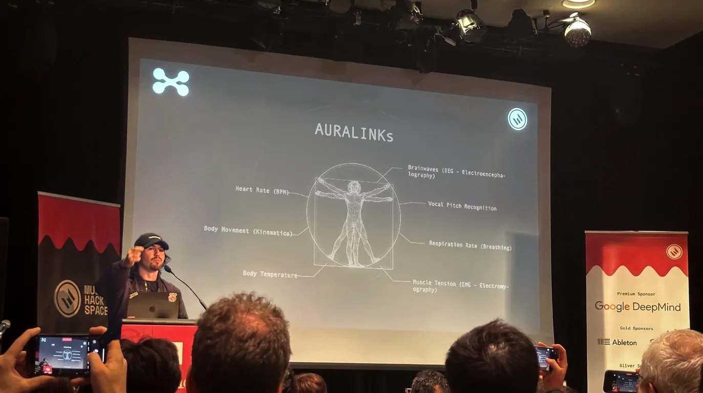 Javier Roqueni presenting the AURALINK biometric sensing architecture on stage, Google DeepMind sponsor banner visible